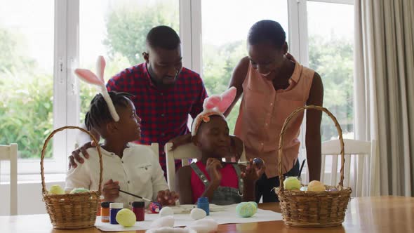 African american family painting easter eggs together at home alt