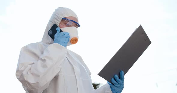 Girl in Chemical Protection Suit Talking the Phone. Coronavirus COVID-19 Pandemic alt