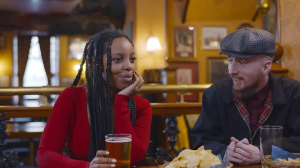 Multiethnic Friends Relaxing and Talking in Beer Bar Greeting Handsome Man alt