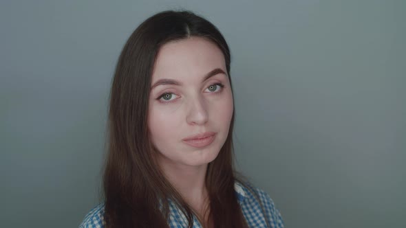 Portrait of Girl's Balanced Smile at Camera on Grey Background alt
