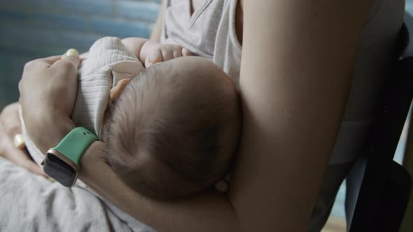 Young Woman Feeds Breast Milk to Her Newborn Baby Closeup alt