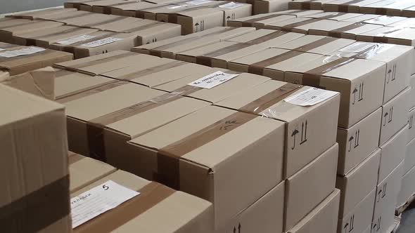 Stacks of Cardboard Boxes in Warehouse of Factory