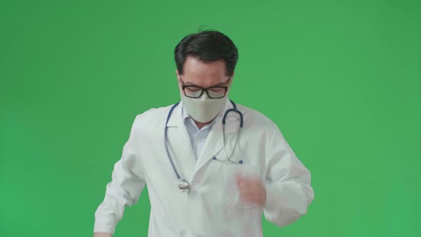 The Front View Of Asian Doctor With Stethoscope Wearing Mask, Running On Green Screen alt
