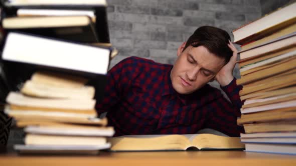 Man Student Boring Reading Book at Library with a Lot of Books in ...