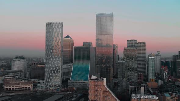 dolly forward Drone aerial shot towards London Canary Wharf buildings at sunset alt