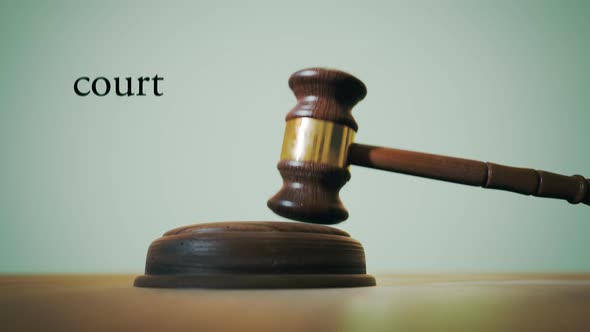 Gavel hitting sound block in a court with a words describing legal profession. alt