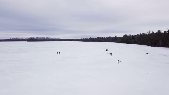 Get an aerial view of Ice Fishing on Fitzgerald Pond, Maine. Here we pass by many small groups. alt