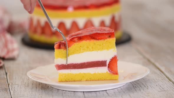 Piece of fresh baked cake with strawberry jelly topping.