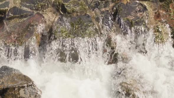 Slow motion. Small waterfall in urban park during Autumn. alt