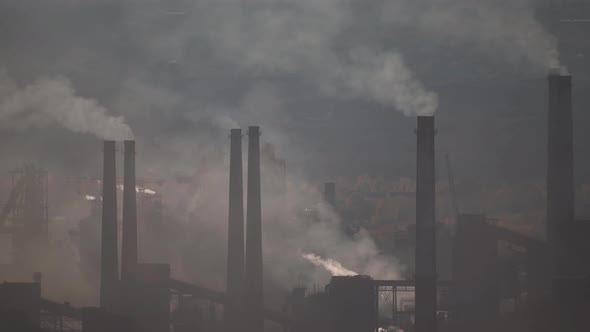 large amount of smoke and soot is emitted from the factory pipes of the metallurgical plant alt