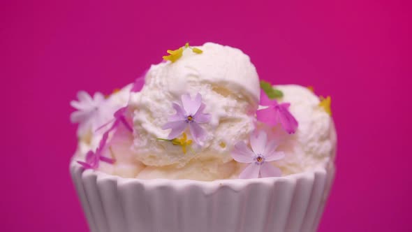 Bowl with tasty vanilla ice cream decorated with edible flowers 