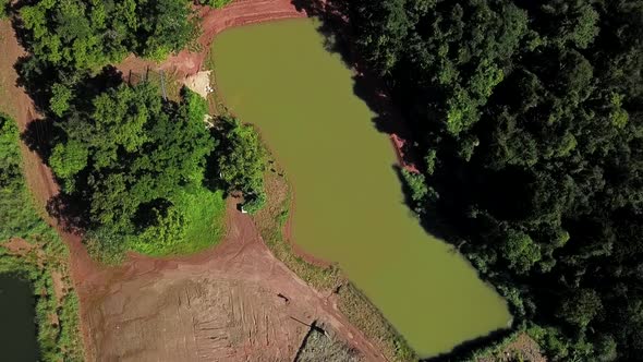 Bird's eye view slowly descending over a commercial fishing pond on a fish farm in the Tocantins reg alt