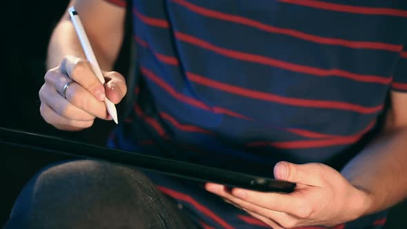 Artist Drawing Sketch on His Tablet Using a Stylus at Home.