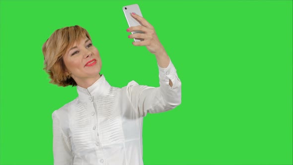 Businesswoman Taking Funny Selfie with Phone on a Green Screen, Chroma Key alt