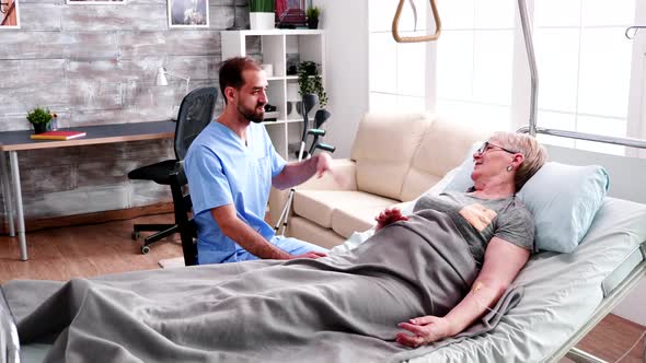 Male Nurse Visit Old Woman Lying in Bed alt