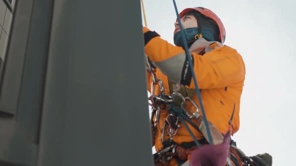 High-altitude Work Industrial Climber Washes a Window View Through Clear Glass, Slow Motion alt