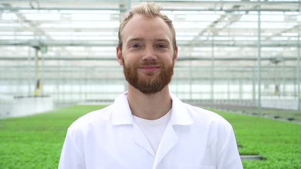 Portrait of Man Agronomist is Posing for Camera and Standing at Hydroponic Greenhouse Spbd alt