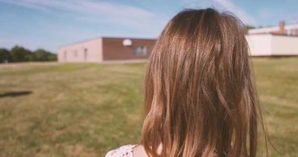 Cute little girl turns around and takes her face mask off. alt