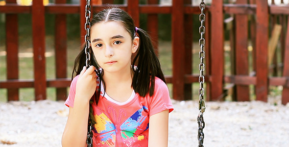 Sad Girl Sits on Swing alt