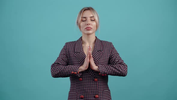 The Beautiful Blonde Joins Her Palms to Her Chest Inhales Exhales Slowly Meditates with Her Eyes alt
