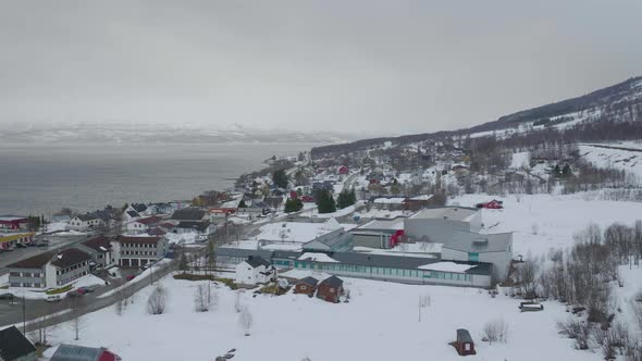 Kåfjord town centre in Olderdalen, Norway. Overcast winter weather.4K aerial drone shot with a side alt