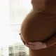 Closeup of the Pregnant Woman Standing Stroking Her Stomach