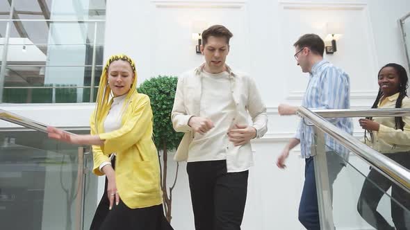 Group of Cheerful Young People Descend the Stairs After the Seminar alt