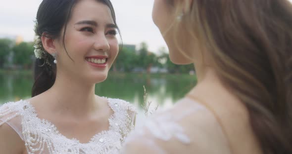 Asian Lesbian Married Couple Enjoying Romantic Moments Outside, Slow Motion. alt