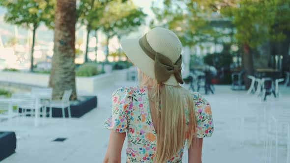 Back View of Blonde Woman Wearing Beautiful Summer Hat with Ribbon Bow