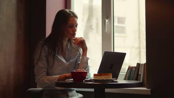 Business Woman Working in a Cafe on a Laptop alt