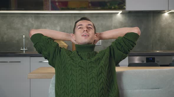Calm Relaxed Young Man Resting on Cozy Sofa at Home alt