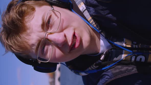 Teenage Blogger in Headphones During an Online Video Broadcast He Holding the Camera at Arm's Length alt