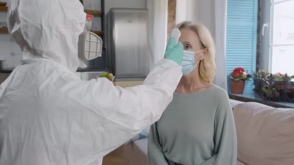Doctor Measures Temperature of Mature Female Patient at Home alt