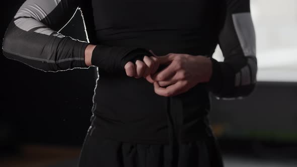 Athletic Young Man Boxer in Sportswear Bandaging His Hands in the Gym alt