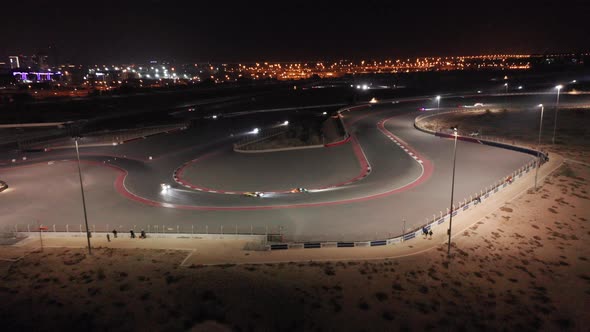 Aerial view of car racing at hairpin, Dubai Autodrome race track during night endurance competition