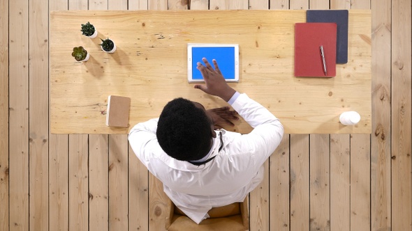 Serious doctor working with a tablet computer in his office alt