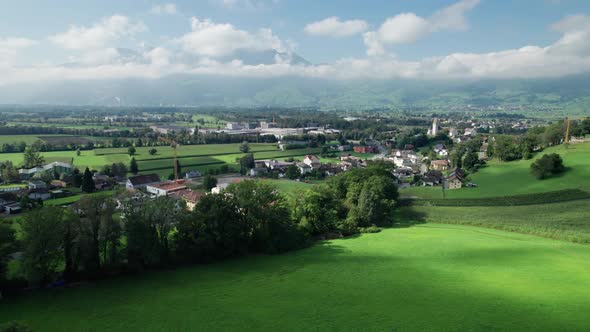 Aerial View of Liechtenstein with Houses on Green Fields in Alps Mountain Valley alt
