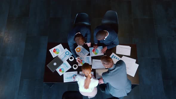 Business people in suits working on a project at a table alt