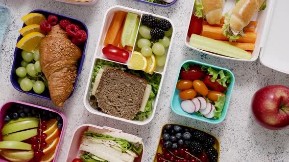 Shot of School Lunchboxes with Various Healthy Nutritious Meals on Stone Background