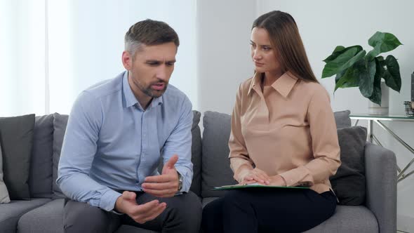Sad Man Patient Talking About His Problem with Woman Psychologist Supporting Him alt