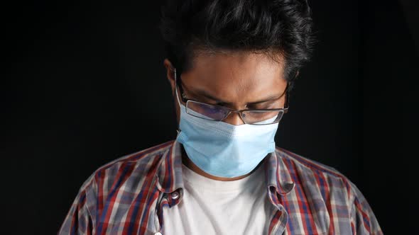 A Young Asian Man with Protective Mask in Face Feeling Sad alt