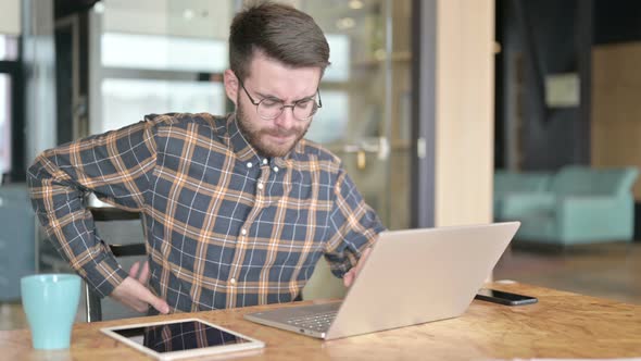 Tired Young Designer Having Back Pain in Office alt