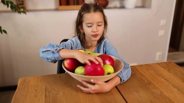 Little Happy Girl Hold Bowl with Fruits in the Kitchen at Home Healthy Child Snack