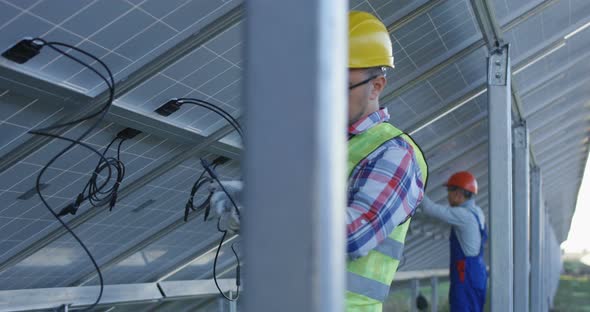 Workers Connecting Wires of Solar Panels alt