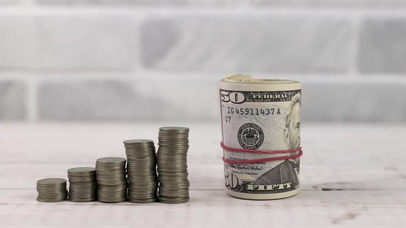 stack of dollar banknotes rolled up with rubber near money coin towers