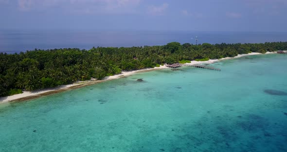 Wide angle flying island view of a white sandy paradise beach and blue water background in 4K