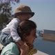 Woman with Toddler on Shoulders Looks at Sea with Binoculars - VideoHive Item for Sale