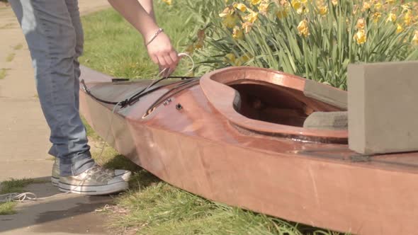 Woman tying knots on canoe alt