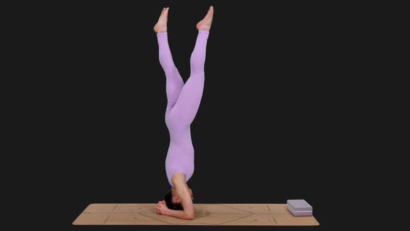 Young Athletic Woman Doing Yoga Headstand Pose on Mat, Alpha in