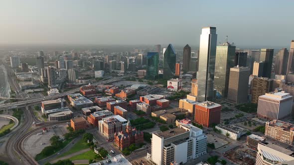 Downtown Dallas Texas skyline. Aerial pan at magic golden hour light. Sunset over Trinity River brid alt